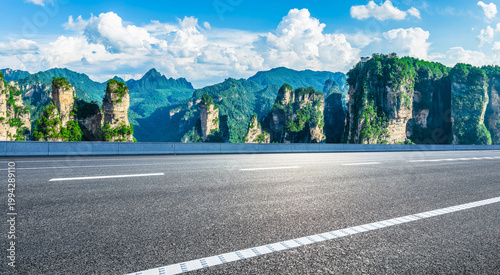 Empty asphalt road leading towards majestic sandstone pillars in Zhangjiajie National Forest Park, China