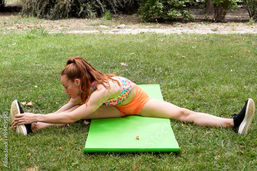 Personal trainer assists with outdoor stretching routine emphasizing proper posture and movement