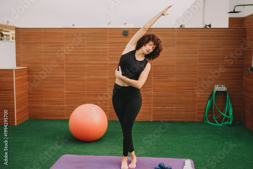 Individual performing mindful yoga poses outside with fitness tools and natural surroundings
