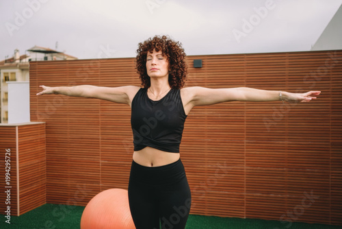 Woman in athletic wear executing fullbody stretching routine during sunrise outdoors