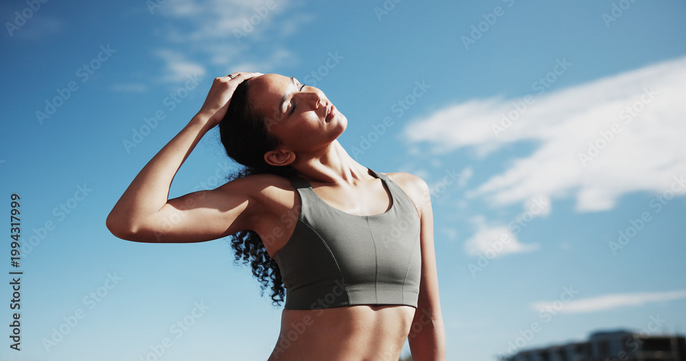 Fototapeta premium Fitness, city and woman stretching neck for exercise, training and warm up for workout with blue sky. Sports, runner and person getting ready for wellness, health or mobility for active hobby in town