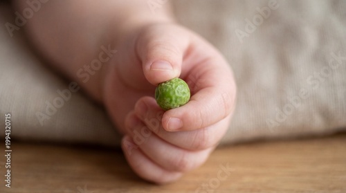 Infant grasping small objects enhances finger dexterity, crucial for developmental milestones in early childhood education.