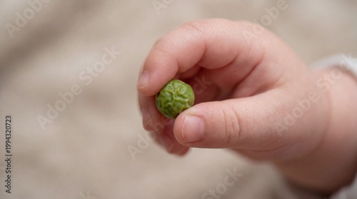 Child's hand holding small object, illustrating fine motor skill development crucial for early childhood learning and growth.