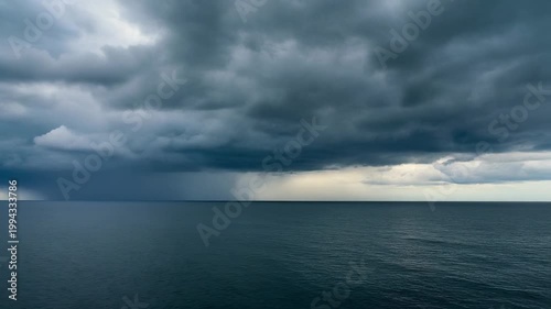 A stormy weather system approaches over a large body of water with dark clouds and rain.