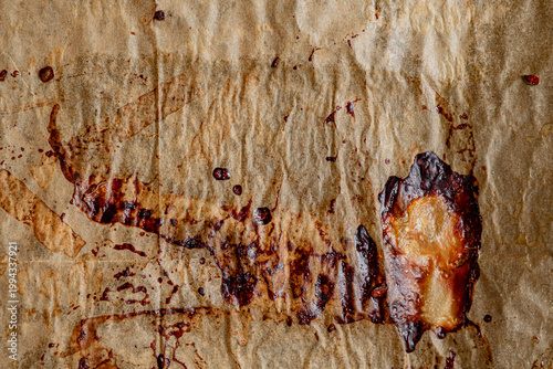 Burnt caramel drips create an intricate pattern on baking paper after a dessert-making adventure
