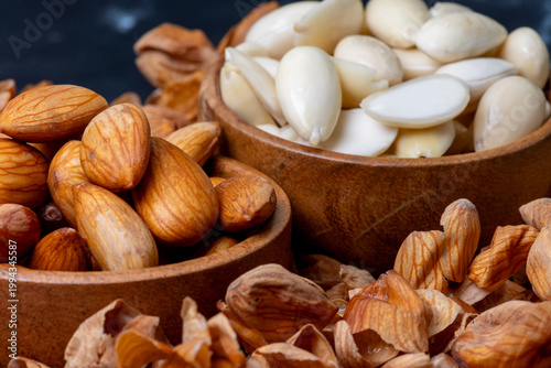 Принти на полотні Two wooden bowls of Soaked almonds n peeled almonds kept on a wooden board surro