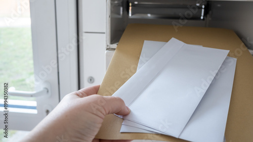 Metal postbox with letter in lobby of modern house.