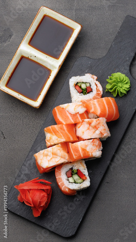 Schilderij op canvas Sushi rolls served on a black plate with dipping sauce and garnish in a restaura