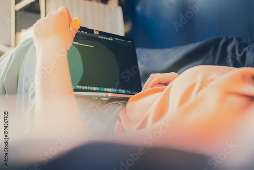 asian woman in casual wear work from home and sit on her bed for protect corona or covid-19 virus