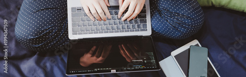 top view asian woman in classic blue pajama cloth work from home with serious feeling and sit on her bed for protect corona or covid-19 virus