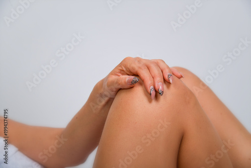 Hand hält schmerzendes Knie – Arthrose, Gelenkschmerzen, Entzündung, Medizin, Gesundheit, Therapie, Rehabilitation, Körper, Nahaufnahme, Copyspace, isoliert