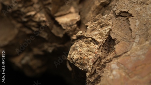 Close-up eroded rock edge with layered cracked earthy texture
