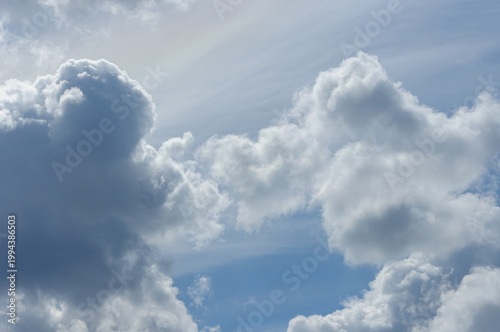 Blue sky with clouds. Sun rays through feathery clouds.