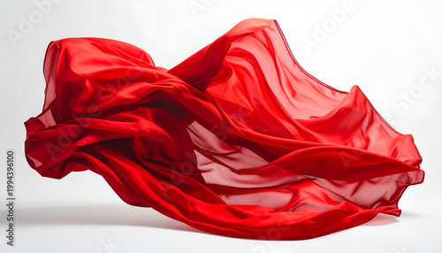A vibrant red fabric gracefully flows and billows against a stark white background, creating a dynamic and artistic composition.