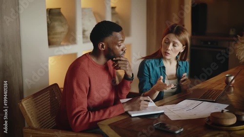 Interracial Couple Managing Finances at Home with Bills and Laptop During Financial Stress and Conflict