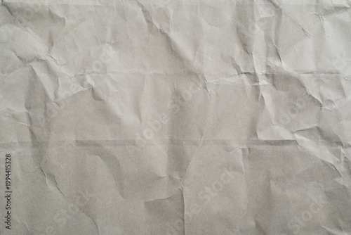 Wrinkled kraft paper texture background with creases, and folds. Neutral beige surface ideal for vintage design, packaging mockup, recycled material concept, abstract backdrop for design layouts arts.