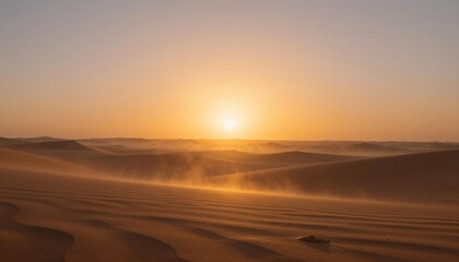 Golden desert sunrise over rippled sand dunes with drifting sand and a warm glowing sky