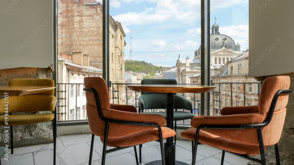 Obraz premium Cozy cafe interior with comfortable seating and a scenic city view through large windows
