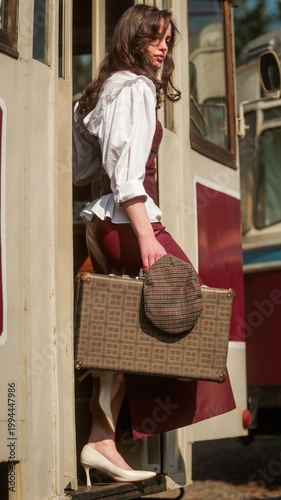 Cuadro en lienzo Woman in vintage attire with suitcase disembarking from a train