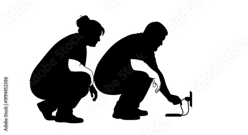 Silhouette of a Man and Woman Squatting and Working Together.