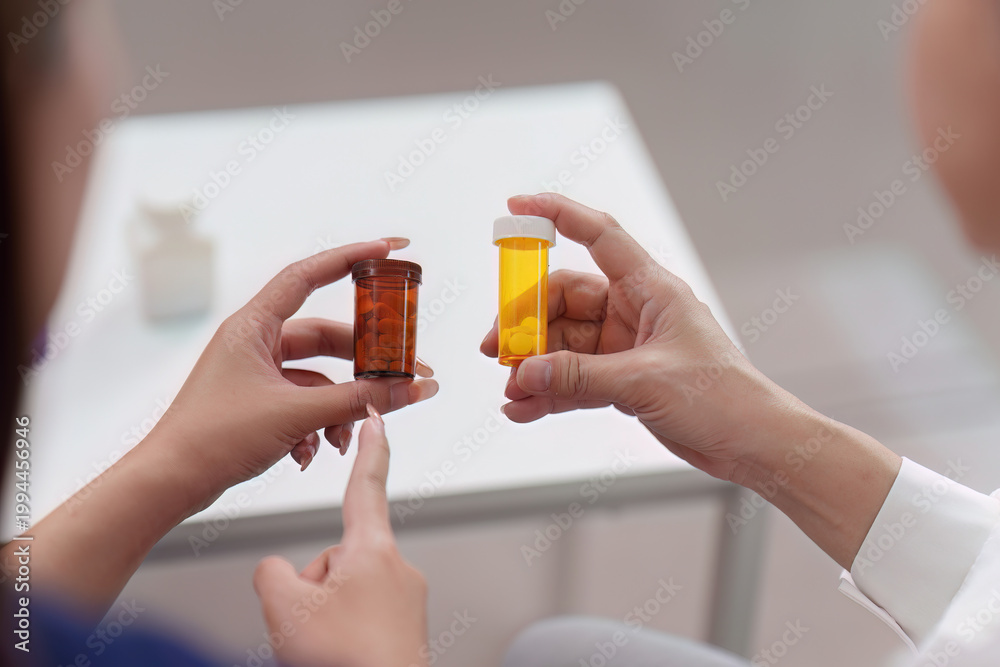 Fototapeta premium Doctor and patient comparing different medication pill bottles for treatment
