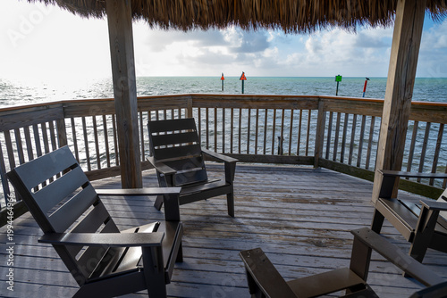 Photos Modern chairs on wooden deck under thatched tiki roof