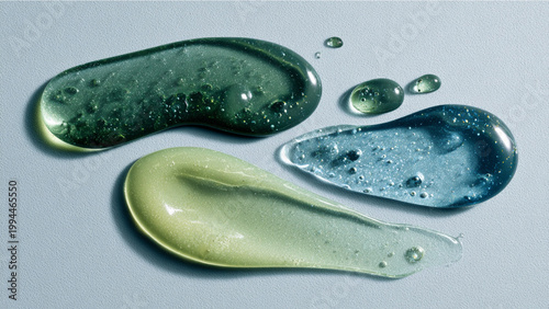 Photorealistic flat lay of three cosmetic product textures on a clean light gray background one deep green gel with air bubbles, one creamy green lotion, and one clear translucent blue serum.