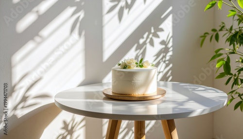 A beautifully decorated white cake sits on a table bathed in sunlight