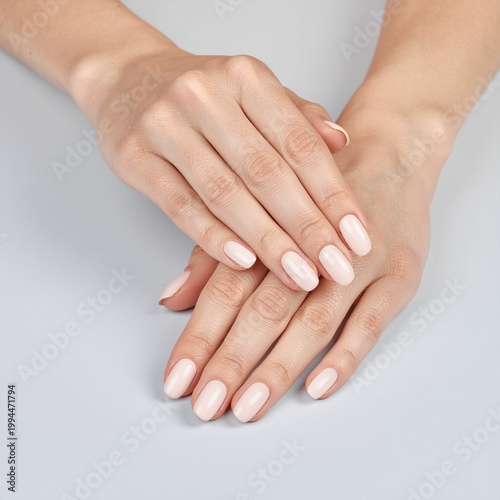 Elegant Hands with Light Pink Manicure on Light Grey Background