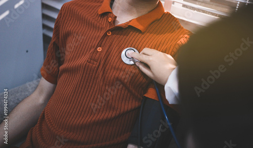 Doctor checks patient's blood pressure with cuff and stethoscope in a medical