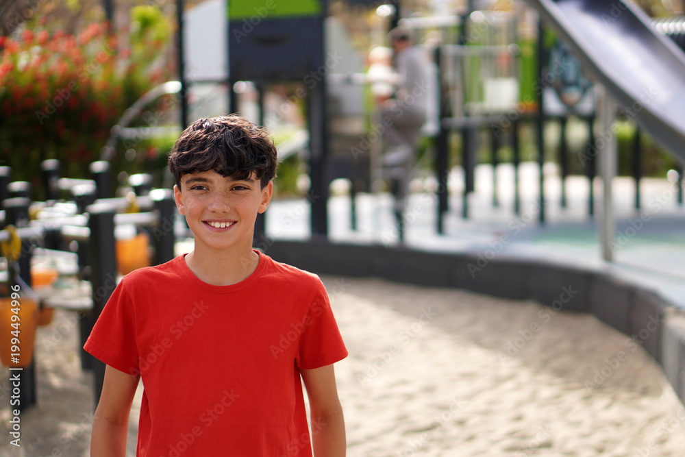 Fototapeta premium Healthy leisure and free time with the family. Preteen boy in the park with his father in the background.