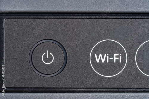 Closeup of power and Wi-Fi buttons on electronic device panel. Macro shot of control panel. Concept of wireless technology modern office equipment and smart home devices