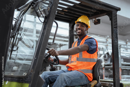 Φωτογραφία Portrait of a worker operator in a metal warehouse wearing personal protective gear sits in a forklift to transport and load heavy materials