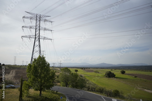 Torres y cables de electricidad de alta tensión con paisaje de campo