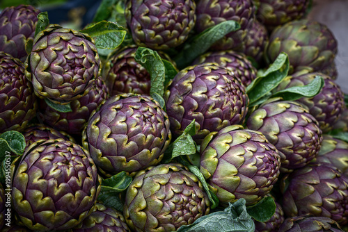 Close-up of fresh green artichokes for sale at a local Italian market.