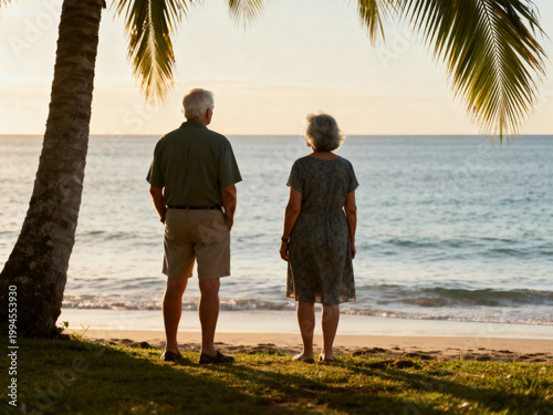 Couple standing near shoreline looking at ocean in peaceful tropical scene