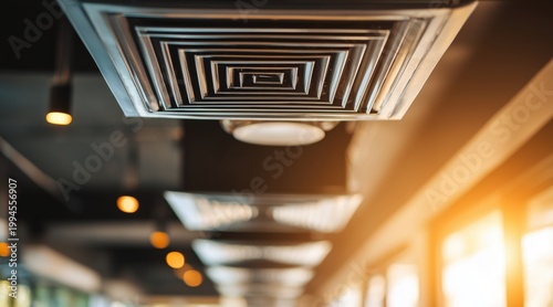 Square air conditioning vents installed on ceiling of modern indoor space