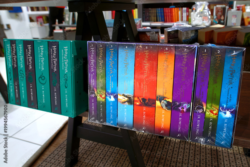 Naklejka premium Minsk, Belarus. Apr 12, 2026. Close up of multiple Harry Potter book boxed sets by J.K. Rowling on wooden display shelf in modern bookstore featuring colorful spines and various editions