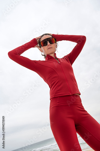Fit Woman in Red Activewear and Sunglasses Standing on Beach, Outdoor Workout