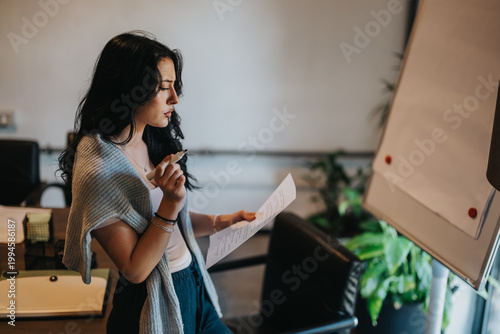 Quadro su tela A student reads notes while preparing to present at a flip chart
