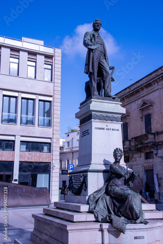 The statue of Sigismondo Castromediano in Lecce honors the patriot, archaeologist, and key figure of the Italian Risorgimento, depicted standing proudly above an allegorical female figure symbolizing 