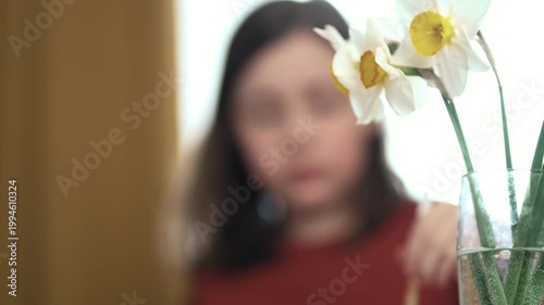 Little girl painting Easter eggs at home, 4K 10-bit cinematic footage of child decorating colorful eggs with watercolor brush for spring holiday, authentic lifestyle.