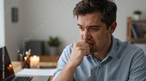 Contemplative man in blue shirt deep in thought at modern workspace