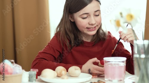 Little girl painting Easter eggs at home, 4K 10-bit cinematic footage of child decorating colorful eggs with watercolor brush for spring holiday, authentic lifestyle.