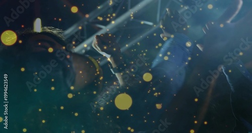 Raising arms, three concertgoers cheering at concert, showing denim sleeve, wristwatch, stage beams