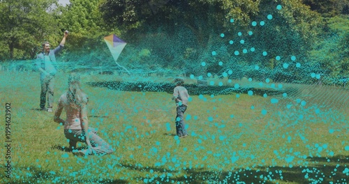 Obraz na plátně Holding man guiding multicolored kite, woman kneeling and boy running on lawn, t
