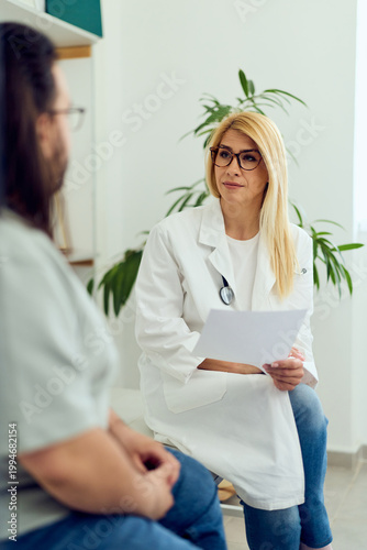 Female Doctor Consultation With Patient In Bright Clinic Reviewing Medical Records And Providing Professional Care