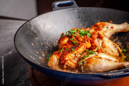 Roasted chicken legs with herbs in hot pan