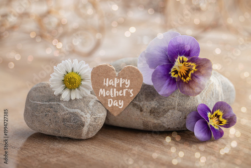 Mother's Day - Greeting card Happy Mother's Day - Decorative heart with blossoms and stones on wood - bokeh - background with light and ornaments
