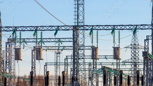 View of an outdoor electrical distribution substation, without people, at daytime on a background of a clear blue sky